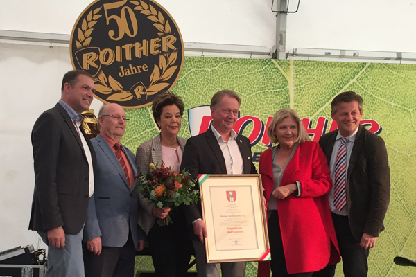Bürgermeisterin Maria-Luise Mathiaschitz und die Stadträte Stadtrat Markus Geiger sowie Christian Scheider überreichen der Familie Roither das Stadtwappen.