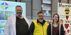 Auf einem Holzpflock ist eine Holztafel befestigt, auf der "Meisterbrief" steht, darunter zeigt ein Pfeil nach rechts